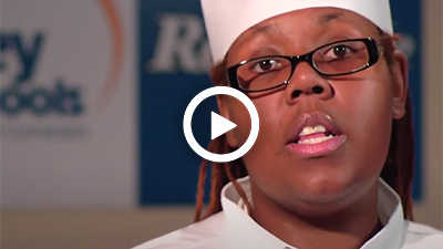 Video play button with culinary arts graduate Alicia.