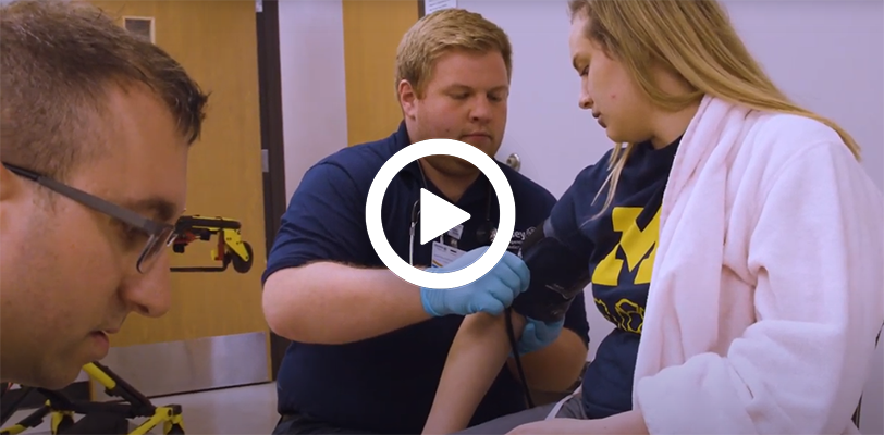 Video play button with an emergency medical technician instructing students.